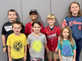 A teacher standing with a group of elementary students